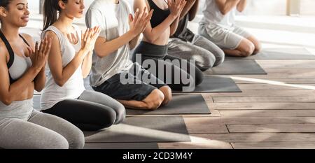 Jeune Yogi multiethnique faisant le geste de Lotus Seal pendant la formation de groupe Dans Studio Banque D'Images