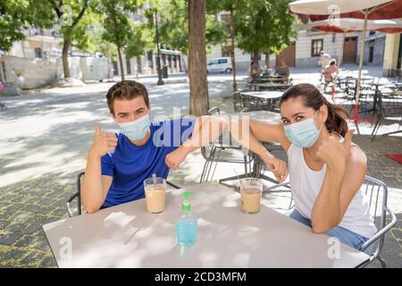 saluez vos amis dans le nouveau style de coude dans un café magasin portant masque chirurgical de protection du visage passer du temps à l'extérieur dans Paramètres publics dans le Corona Banque D'Images