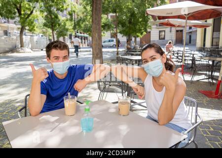 saluez vos amis dans le nouveau style de coude dans un café magasin portant masque chirurgical de protection du visage passer du temps à l'extérieur dans Paramètres publics dans le Corona Banque D'Images