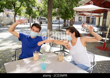 saluez vos amis dans le nouveau style de coude dans un café magasin portant masque chirurgical de protection du visage passer du temps à l'extérieur dans Paramètres publics dans le Corona Banque D'Images