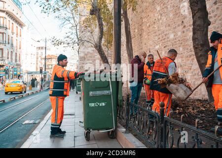 18.12.2019, Istanbul, Turquie. Les travailleurs en uniforme ont enlevé les feuilles et placé la benne à ordures. Rue de la ville. Vue latérale. Banque D'Images