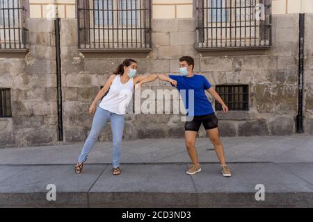 Le nouveau style normal et de message d'accueil. L'homme et la femme qui secouent les coudes ou les pieds en gardant la distance sociale pour éviter la propagation du coronavirus. Éclosion de la COVID-19 et d Banque D'Images