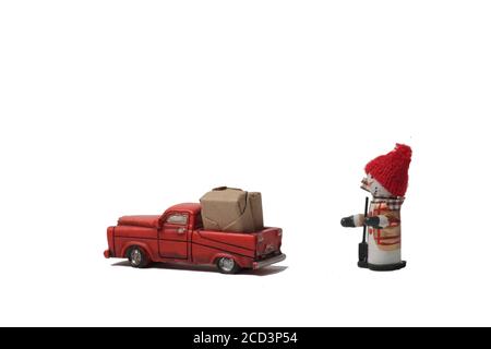 bonhomme de neige et pick-up rouge chargés de boîtes enveloppées isolées sur fond blanc. L'image contient de l'espace de copie Banque D'Images