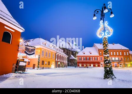 La place principale et l'église noire de Brasov, en Transylvanie, en Roumanie, ont fait l'hiver. Banque D'Images