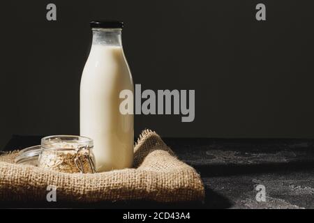 Bouteille en verre de lait d'avoine avec flocons d'avoine en verre pot Banque D'Images