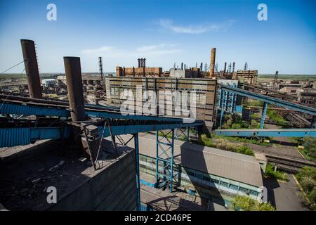 Usine de métallurgie soviétique. Des bâtiments d'usine abandonnés, des transporteurs de transporteurs bleus et des cheminées rouillées sur le ciel bleu. Vue plongeante (aérienne). Taraz Banque D'Images