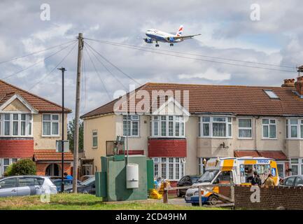 Aéroport de Heathrow, Londres, Royaume-Uni. 26 août 2020. Vol de British Airways au-dessus de Myrtle Avenue à l'approche de la piste 27L à Heathrow en vent de rafales, les restes de Storm Francis. En premier plan, une fourgonnette de glace visite l'avenue. Crédit : Malcolm Park/Alay Live News. Banque D'Images