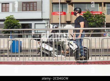 Homme à cheval sur une monoroue électrique, auto-équilibrant tricycle électrique sur la voie du cycle en Espagne Banque D'Images