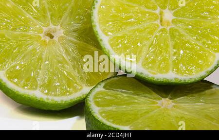Tranches de fruits frais et jus de citron vert, plein cadre Banque D'Images