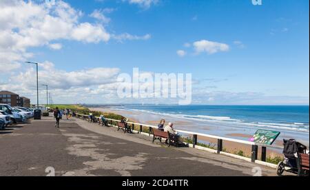Les gens se sont assis sur les bancs de la promenade en admirant la vue À Saltburn by the Sea, Angleterre, Royaume-Uni Banque D'Images