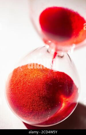hourglass au sable rouge utilisé pour mesurer le flux temporel, la macro photographie Banque D'Images