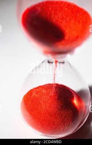 hourglass au sable rouge utilisé pour mesurer le flux temporel, la macro photographie Banque D'Images