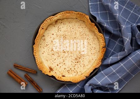 Morceau de tarte à la crème de sucre maison sur une assiette blanche sur fond gris, vue de dessus. Pose à plat, en hauteur, par le dessus. Banque D'Images