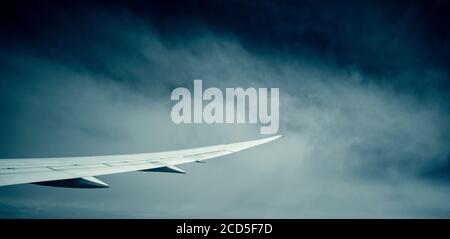 Photographie de l'aile d'avion avec des nuages en arrière-plan Banque D'Images