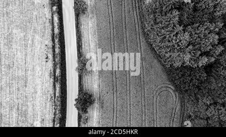 Directement au-dessus de la vue de la route à travers le paysage rural en noir et blanc Banque D'Images