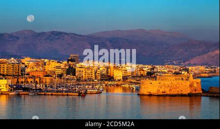 Première lumière du matin au vieux port d'Héraklion, Crète, Grèce. À droite, château de Kules. En arrière-plan, Psiloritis montagne. Banque D'Images