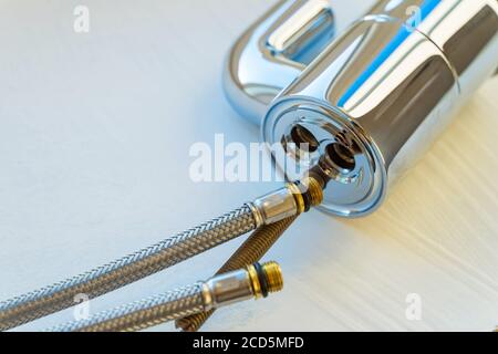 Vue de dessus du robinet mélangeur chromé, raccords de tuyau flexible sur fond blanc. Banque D'Images