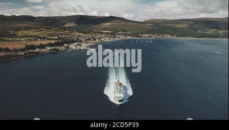 Scotland Ocean, ferry pour passagers vue aérienne sur les eaux côtières du golfe de Firth-of-Clyde. Traversée en bateau depuis le terminal Brodick vers le continent écossais. Paysage urbain dans les vallées verdoyantes. Prise de vue cinématographique Banque D'Images