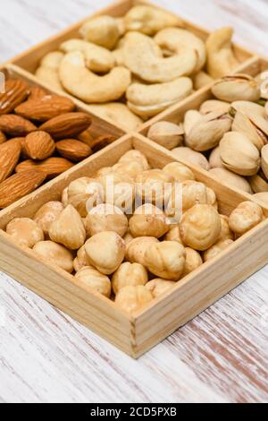 Gros plan de noisettes dans une boîte en bois. Assortiment de noix en arrière-plan. Banque D'Images