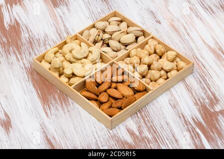 Gros plan de pistaches dans une boîte en bois. Assortiment de noix en arrière-plan. Banque D'Images