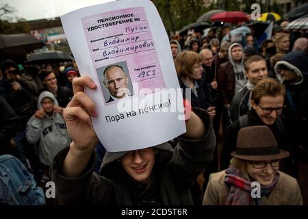 Moscou, Russie. 7 octobre 2017. Les gens assistent à un rassemblement non autorisé contre le Kremlin, appelé par le chef de l'opposition Alexei Navalny, qui purge une peine d'emprisonnement de 20 jours, dans le centre-ville de Moscou le jour du 65e anniversaire du président Vladimir Poutine. Un jeune homme est titulaire d'un certificat de pension avec le portrait de Vladimir Poutine avec l'inscription « il est temps de prendre sa retraite » Banque D'Images