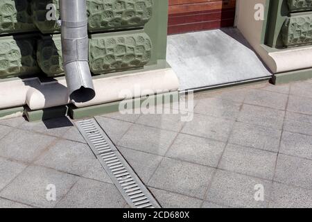 construction d'ingénierie urbaine descente sur bâtiment de façade verte avec grille de drainage de pierre grise trottoir en granit de carreaux carrés avec espace de copie, c Banque D'Images