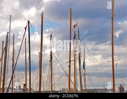 Beaucoup de beaux bateaux à voile avec de hauts pôles dans un petit port de plaisance près de Flensburg/Allemagne en face d'un ciel nuageux et venteux Banque D'Images