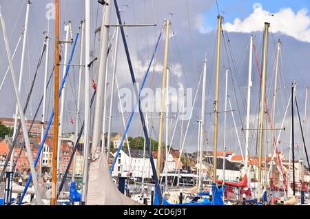 Beaucoup de beaux bateaux à voile avec de hauts pôles dans un petit port de plaisance près de Flensburg/Allemagne en face d'un ciel nuageux et venteux Banque D'Images