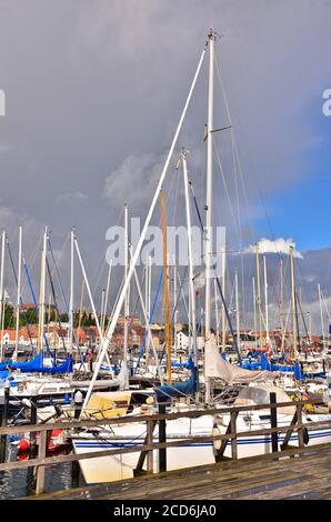 Beaucoup de beaux bateaux à voile avec de hauts pôles dans un petit port de plaisance près de Flensburg/Allemagne en face d'un ciel nuageux et venteux Banque D'Images