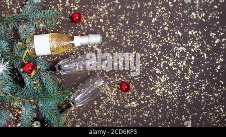 Fond de Noël avec bouteille de champagne, branches de sapin et décorations de Noël sur fond sombre vue du dessus. Nouvelle année, bannière de Noël. Banque D'Images