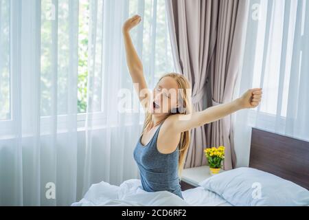 Jeune femme se réveillant heureusement, après une bonne nuit de sommeil Banque D'Images