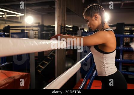 caleçon de femme caucasienne fatiguée debout se pencher sur la clôture, après l'entraînement réussi dans l'anneau. Concept sport Banque D'Images