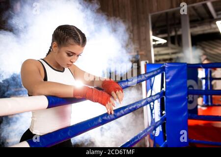 caleçon de femme caucasienne fatiguée debout se pencher sur la clôture, après l'entraînement réussi dans l'anneau. Concept sport Banque D'Images