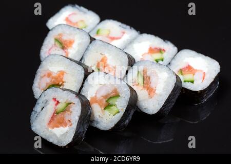 Les sushis roulent le Futo Maki sur fond noir. Banque D'Images