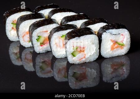 Les sushis roulent le Futo Maki sur fond noir. Banque D'Images