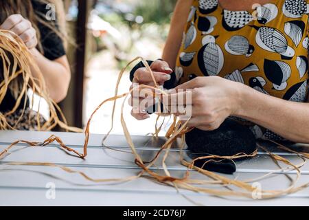 Panier à tisser femelle sur l'atelier d'artisanat. Mains tenant l'artisanat, gros plan. Banque D'Images