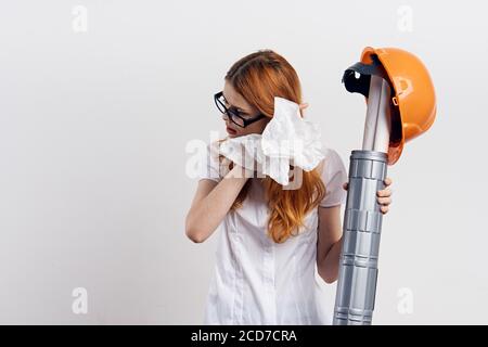 Femme en lunettes orange casque tube dessins construction fond clair Banque D'Images