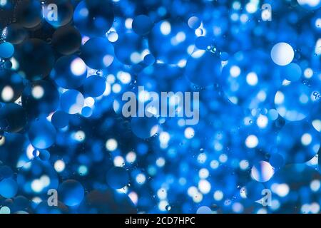 Photo macro du mélange de l'huile et de l'eau. Gouttelettes d'huile au-dessus d'un magnifique fond abstrait coloré créant des cercles et des ovales. Décoration de Noël Banque D'Images