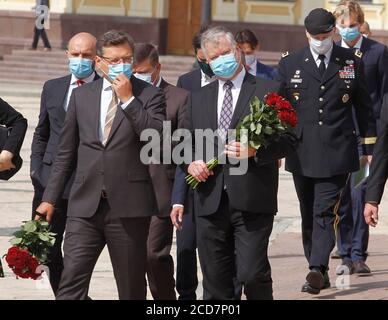 Kiev, Ukraine. 27 août 2020. LE secrétaire d'État ADJOINT AMÉRICAIN Stephen Biegun (C) et le ministre ukrainien des Affaires étrangères Dmytro Kuleba (L) portant des masques faciaux participent à une cérémonie de pose de fleurs sur le mur commémoratif des militaires ukrainiens tués dans le conflit de guerre dans l'est du pays. Stephen Biegun, secrétaire d'État adjoint, se trouve à Vilnius, en Lituanie, à Moscou, en Russie, à Kiev, en Ukraine, du 24 au 27 août 2020, pour rencontrer des hauts dirigeants du gouvernement afin de discuter d'une gamme de questions régionales et internationales, a informé le département d'État des États-Unis. Crédit : SOPA Images Limited/Alamy Live News Banque D'Images
