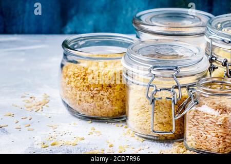 Céréales variées en pots de verre : kinoa, bulgur, couscous, orzo, riz brun, foyer sélectif Banque D'Images