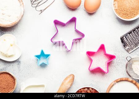 Composition de Noël ou du nouvel an avec ingrédients pour cuire ou biscuits, avec flocons de neige dorés, boules de Noël, sur fond gris, avec cuisson pour Banque D'Images