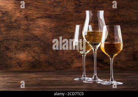 Ensemble vin blanc. Dégustation de vins, les variétés de vins blancs les plus populaires dans des verres à vin sur une table en bois vintage dans un style rustique, concentration sélective Banque D'Images