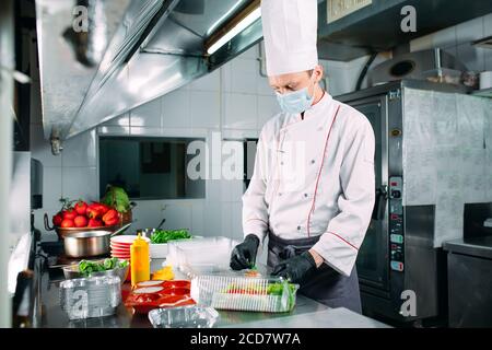Livraison de nourriture au restaurant. Le chef prépare des plats au restaurant et les prépare dans des plats jetables. Banque D'Images