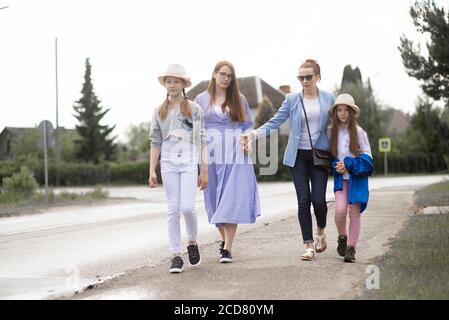 Deux femmes mères sœurs femmes d'affaires vont pour une promenade avec un chapeau de soleil d'été pour les filles Banque D'Images