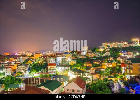 Vue sur la ville de la station avec de nombreuses maisons près de la la mer au loin dans les lumières de nuit des montagnes Banque D'Images