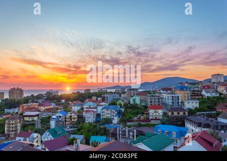 Vue sur la ville de la station de nombreuses maisons sur la mer côte dans les montagnes au loin dans la soirée au coucher du soleil Banque D'Images