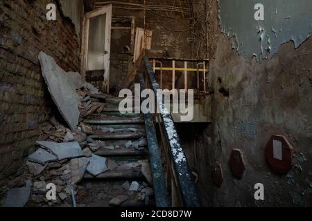 Détruit les escaliers vers le deuxième étage d'un jardin d'enfants dans la ville de Pripyat, zone d'exclusion de Tchernobyl, Ukraine Banque D'Images