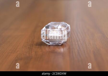 Une boîte en cristal avec des anneaux de mariage sur une table en bois Banque D'Images