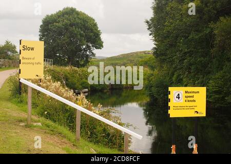 Vue de deux panneaux d'avertissement pour les navires voyageant le long du canal de Crinan, Argyll, en Écosse, dont l'un indique la limite de vitesse Banque D'Images