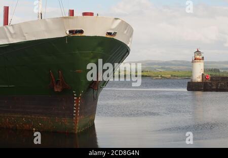 Vue rapprochée de l'arc et des ancres d'un bateau Timber Link à l'embarcadère d'Ardrishaig, Argyll, en Écosse, qui attend d'être chargé et du phare Banque D'Images